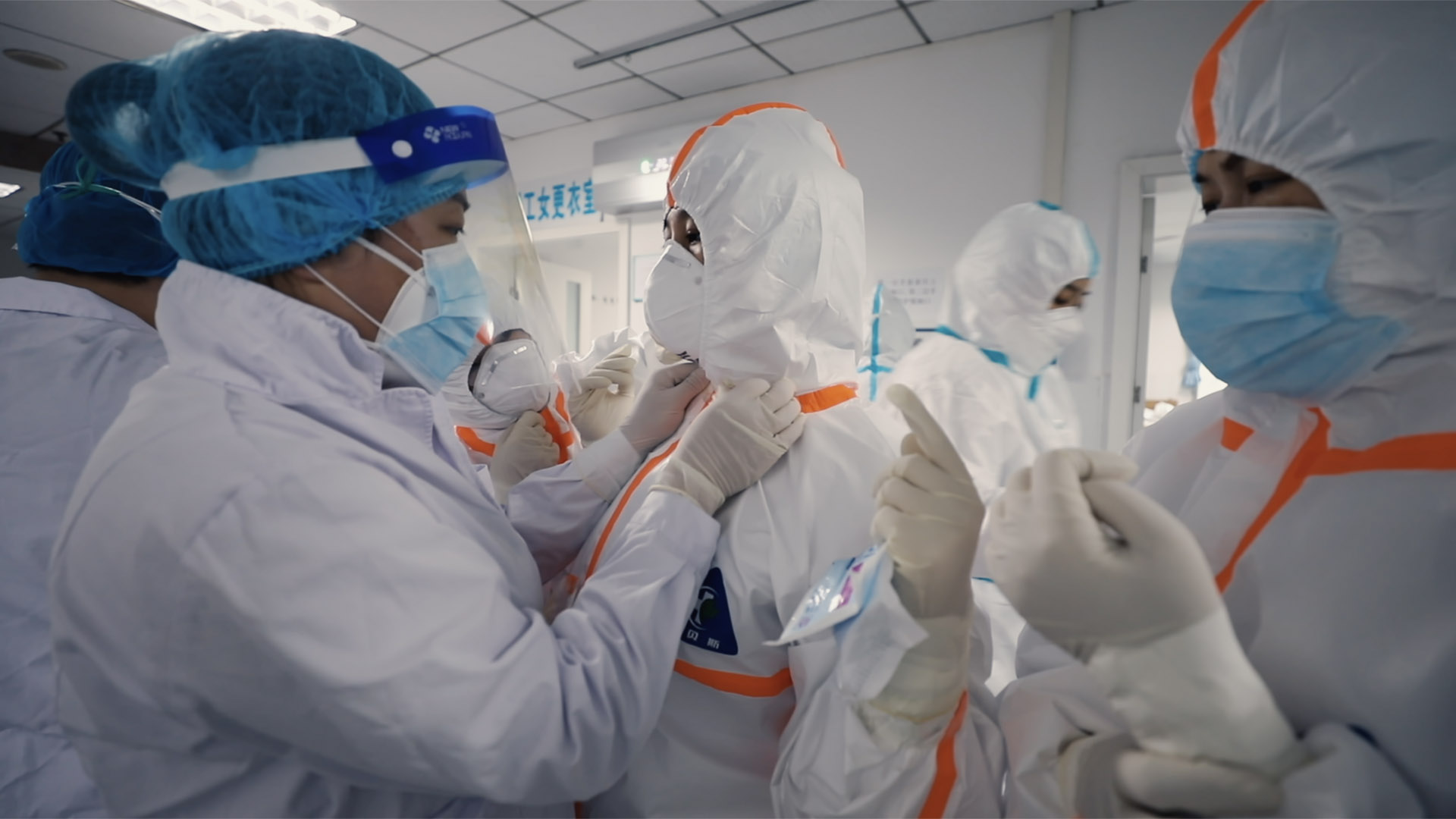 Trailer still frame from 76 Days, people in hazmat suits and surgical gear