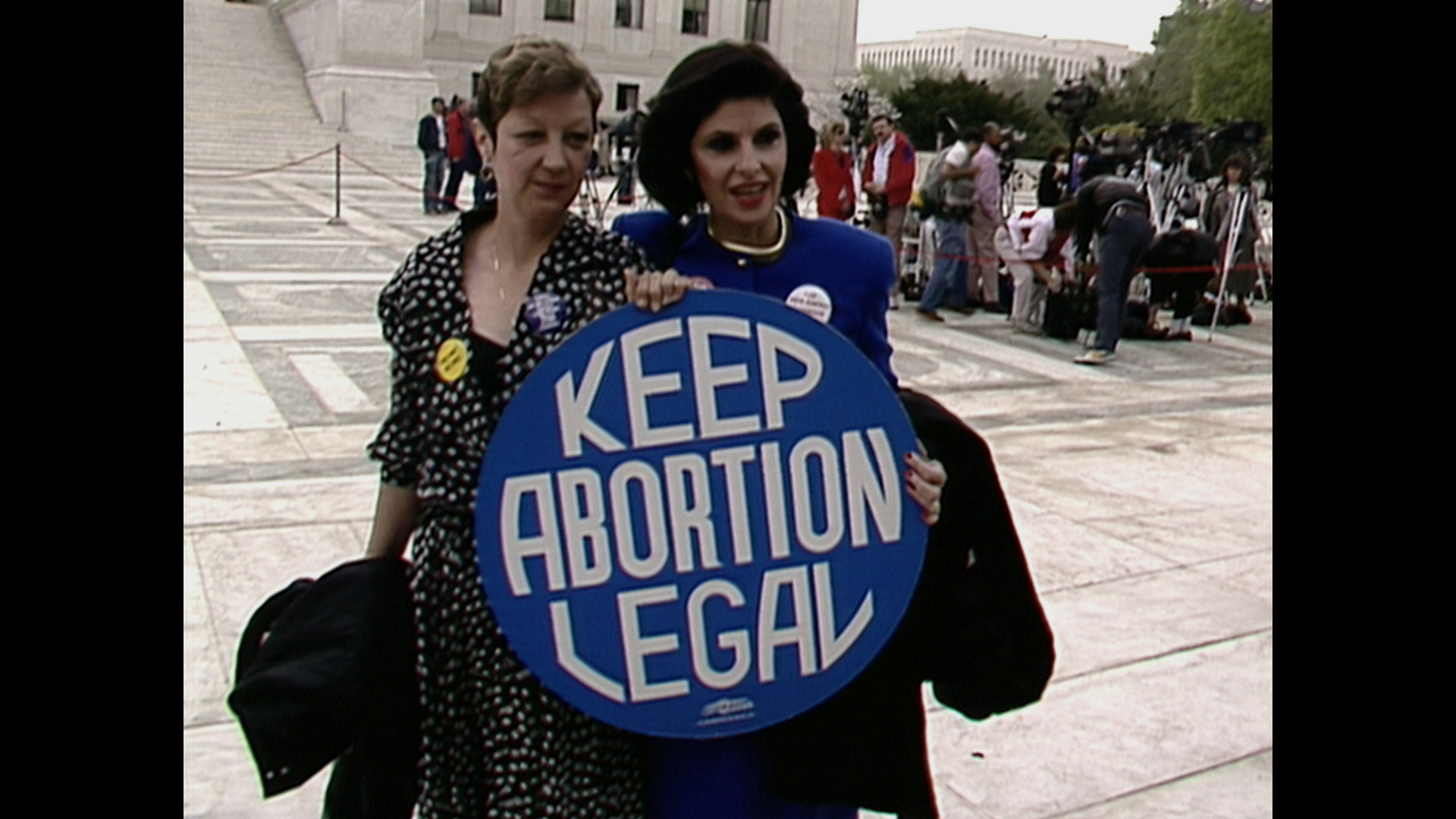 Trailer still frame from AKA Jane Roe, two women holding sign "keep abortion legal"