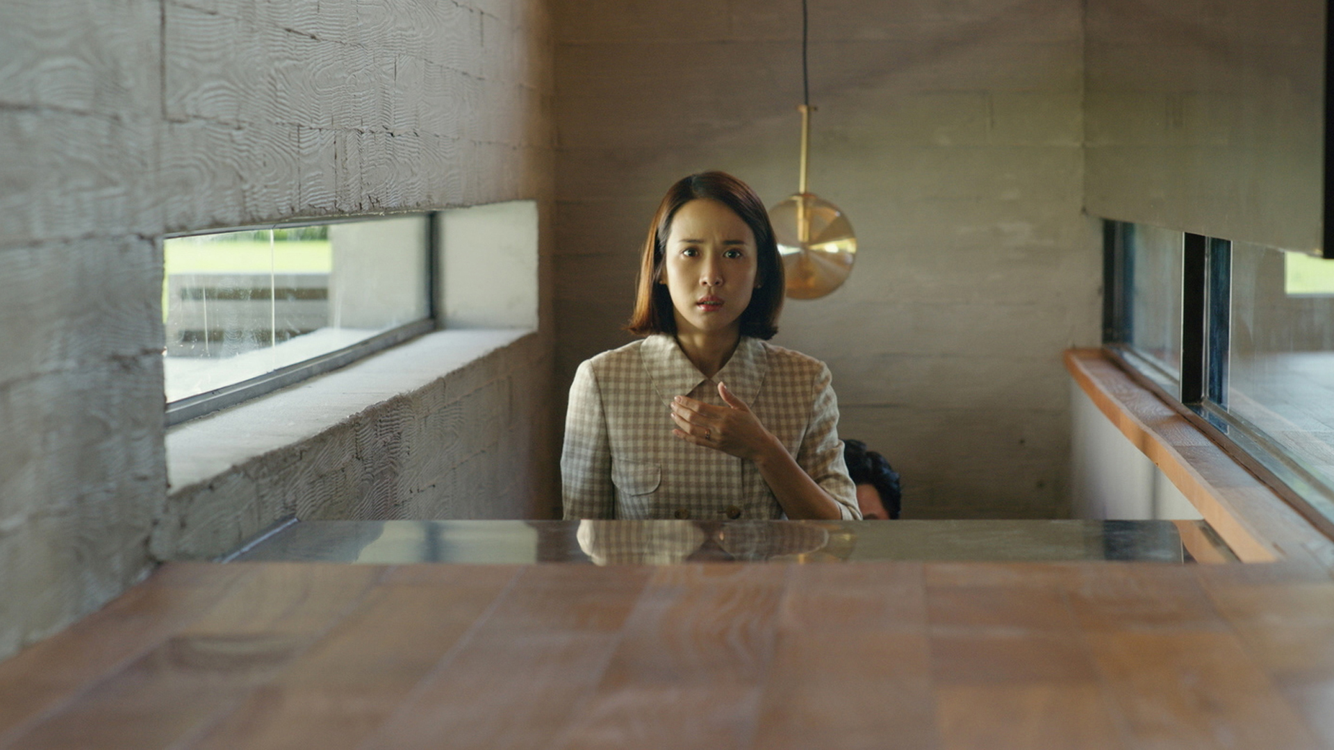 Trailer still frame from Parasite, woman with man behind her