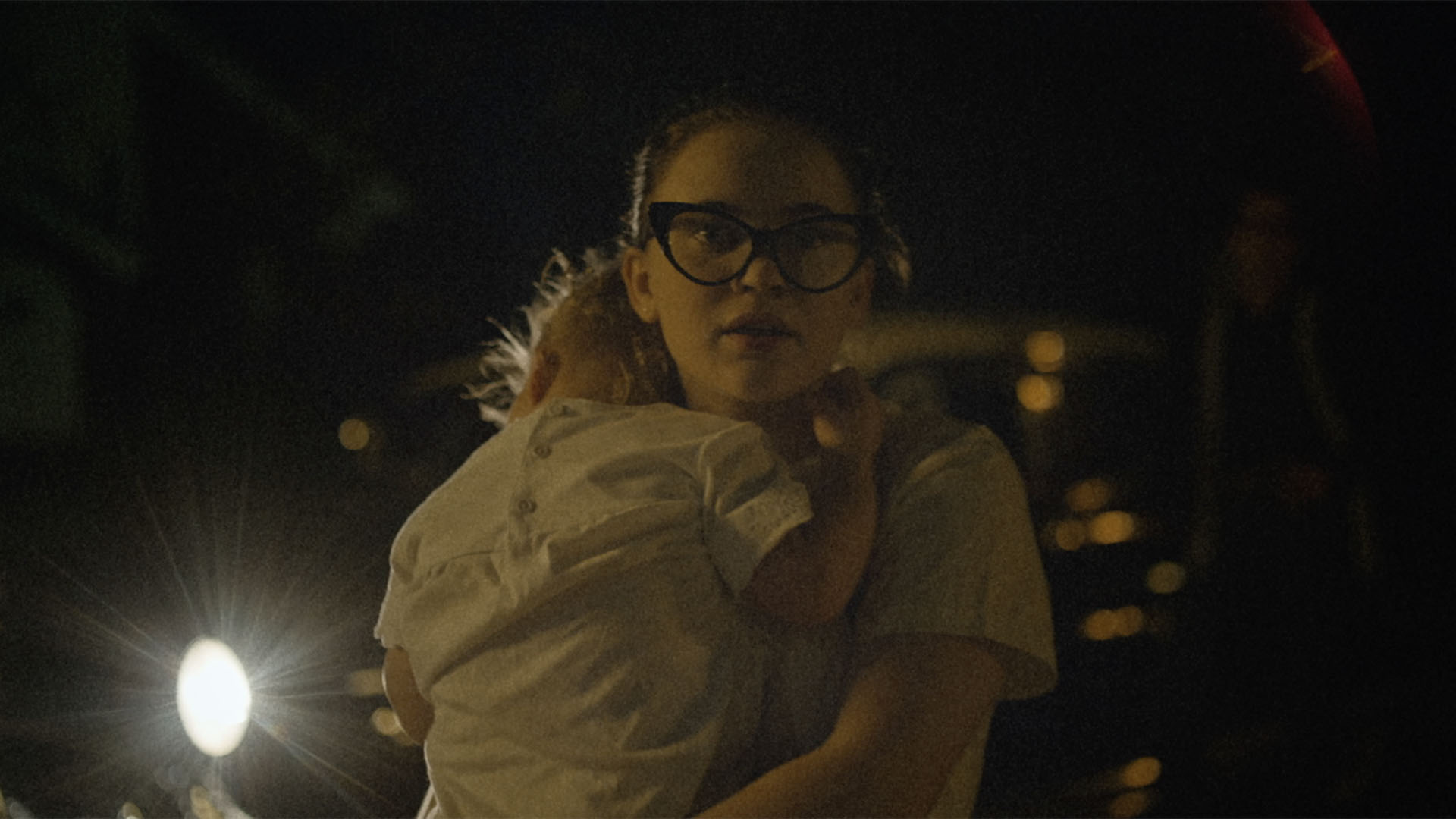 Trailer still frame from The Vast of Night, woman holding child
